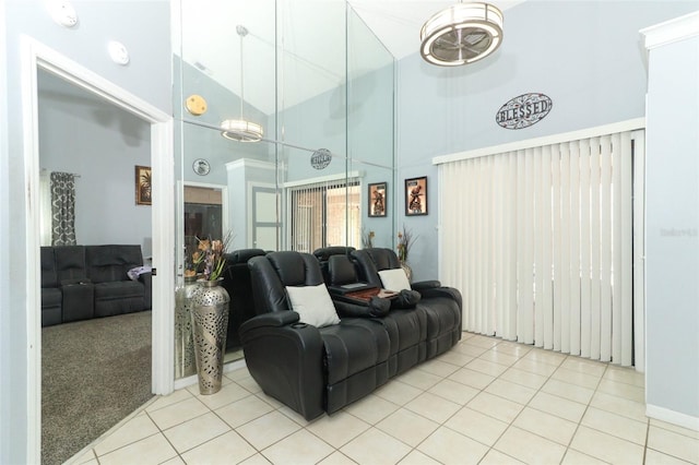 living area with light tile patterned floors, light carpet, and a towering ceiling