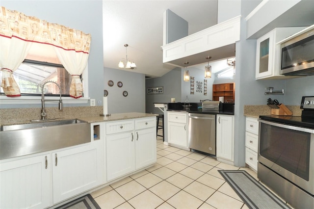 kitchen with appliances with stainless steel finishes, white cabinetry, sink, light tile patterned floors, and kitchen peninsula