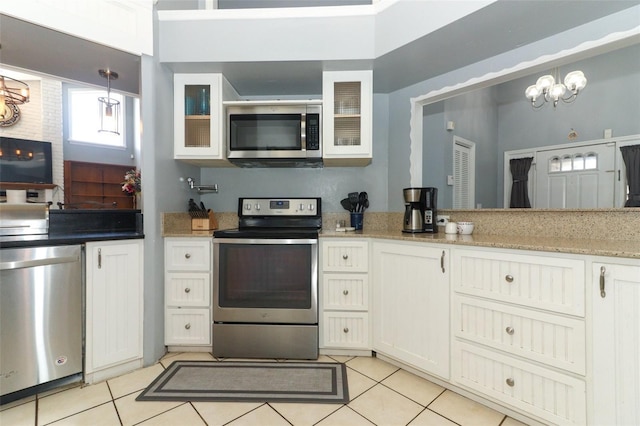 kitchen featuring white cabinets, light tile patterned floors, a chandelier, and stainless steel appliances