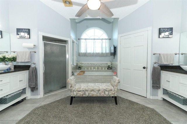 full bathroom with tile patterned flooring, vanity, vaulted ceiling, a bath, and a stall shower