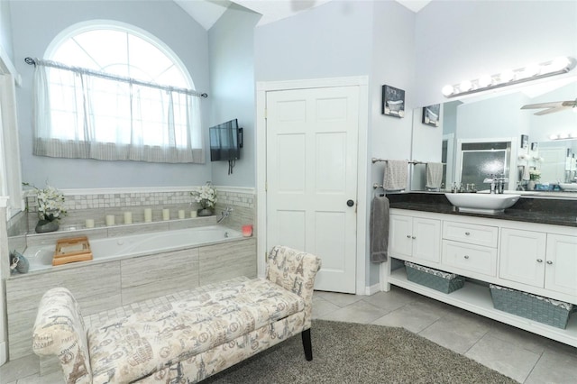 bathroom featuring high vaulted ceiling, tile patterned flooring, vanity, ceiling fan, and a relaxing tiled tub