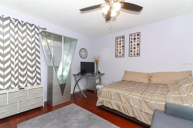 bedroom featuring dark hardwood / wood-style flooring, a textured ceiling, and ceiling fan