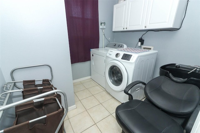 washroom with cabinets, independent washer and dryer, and light tile patterned floors