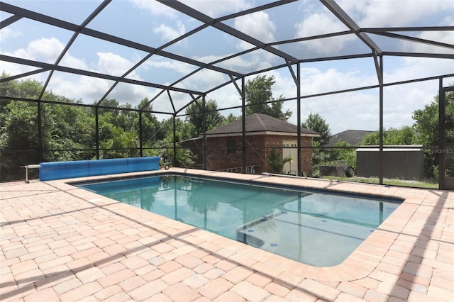 view of swimming pool featuring glass enclosure and a patio