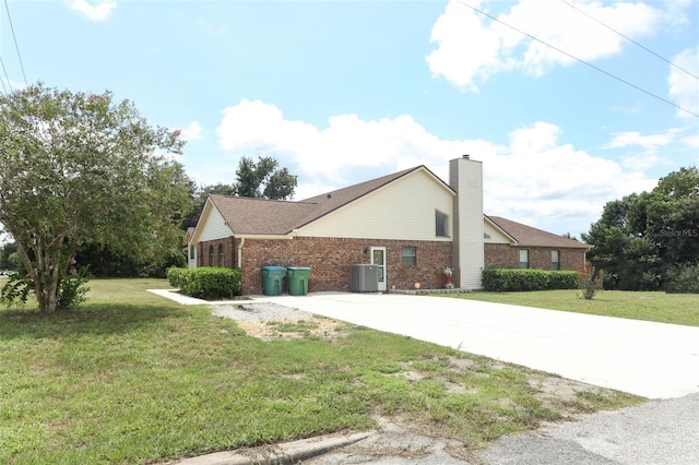 view of front of house featuring central air condition unit and a front yard