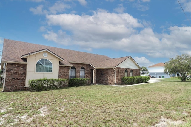 ranch-style house with a front yard, brick siding, and roof with shingles