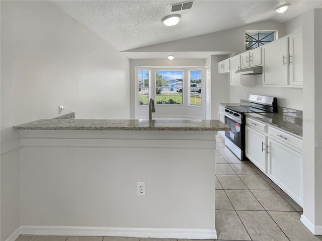 kitchen featuring electric range, vaulted ceiling, and white cabinets