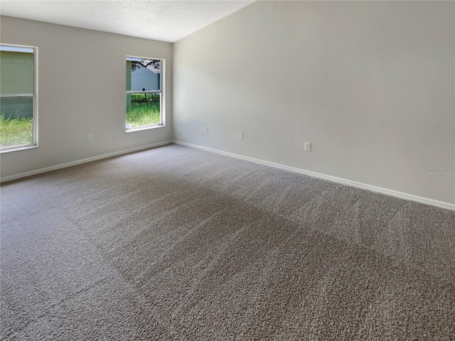 carpeted empty room with a textured ceiling