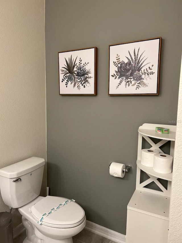 bathroom with toilet and baseboards