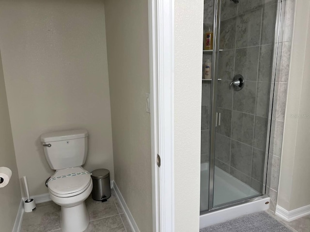 bathroom with a stall shower, tile patterned flooring, toilet, and baseboards