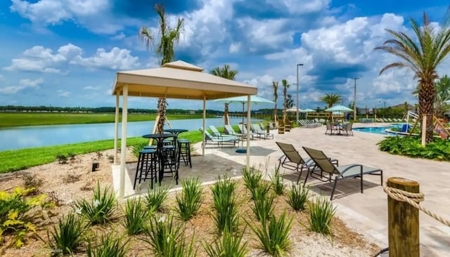 surrounding community with a gazebo, a patio, a pool, and a water view