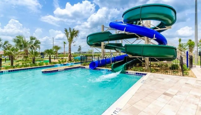 pool featuring a water slide and a hot tub