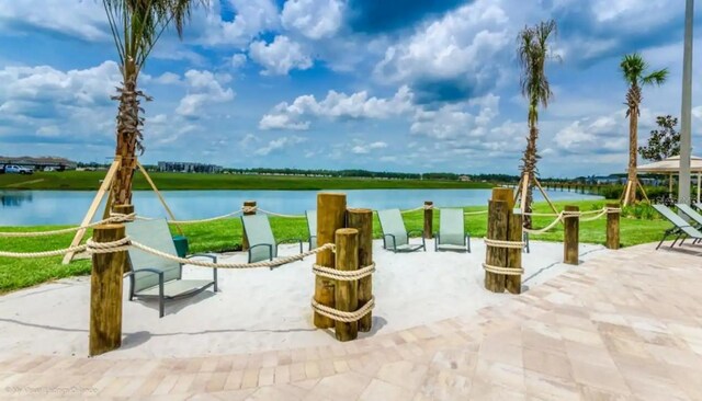 surrounding community with a water view and a patio area