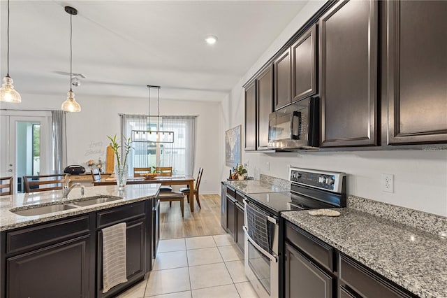 kitchen featuring decorative light fixtures, electric range, a sink, light stone countertops, and black microwave