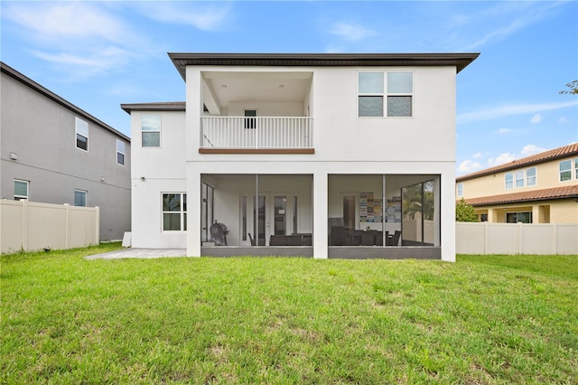 back of property with a lawn, fence, and stucco siding