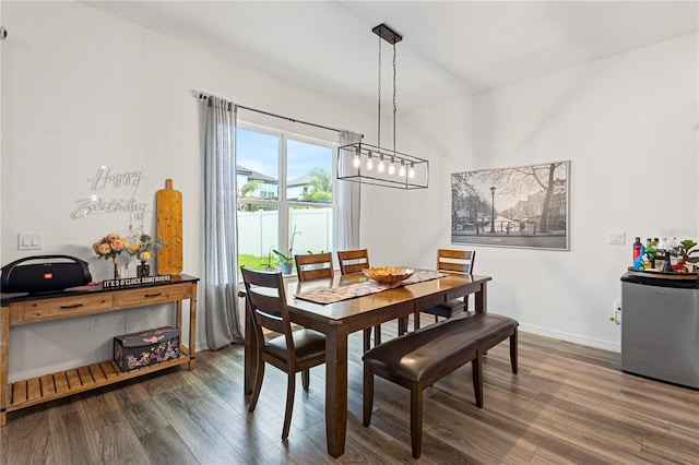 dining area with baseboards and dark wood-type flooring