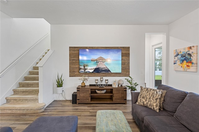 living area with stairs and wood finished floors