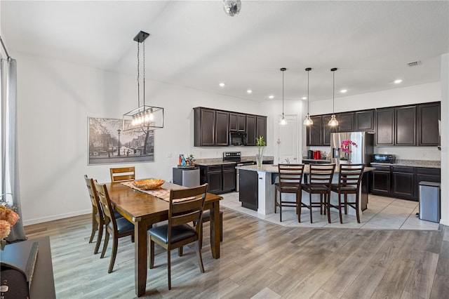 dining area featuring light wood-style flooring, recessed lighting, visible vents, baseboards, and an inviting chandelier