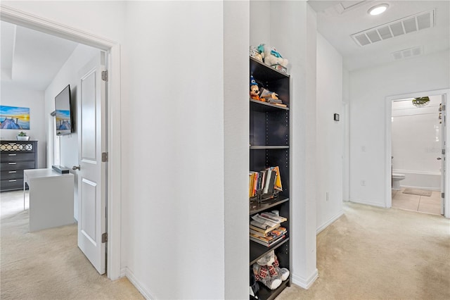 hall with visible vents and light colored carpet