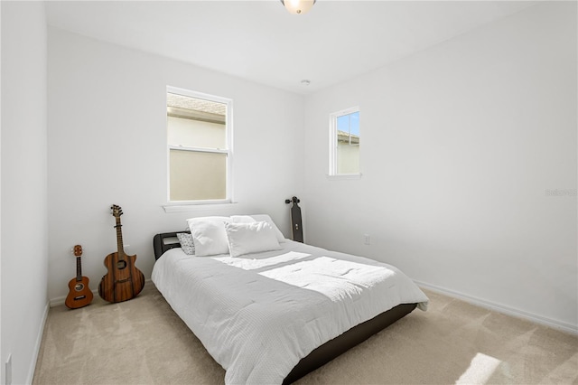 bedroom with light carpet and baseboards