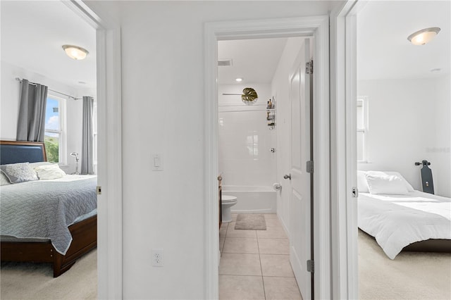 bedroom featuring light tile patterned floors and connected bathroom