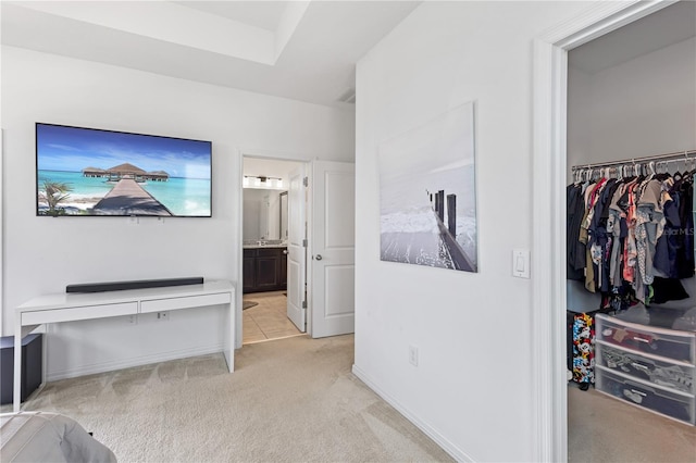 hallway featuring baseboards and light colored carpet