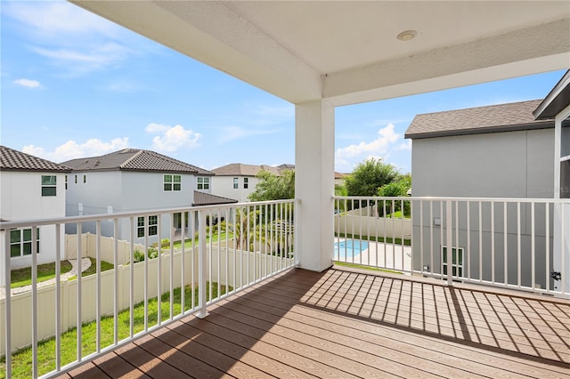 wooden deck featuring a residential view and a fenced in pool