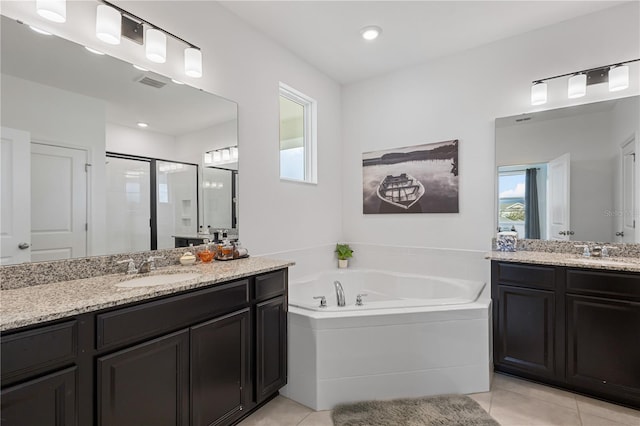 bathroom featuring tile patterned flooring, two vanities, a sink, and a shower stall