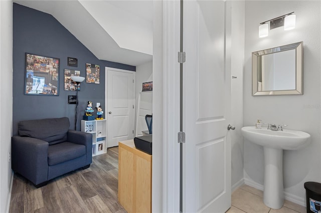 bathroom featuring a sink, wood finished floors, and baseboards