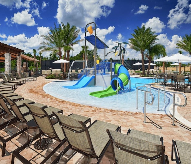 communal playground with a water play area, a community pool, and fence