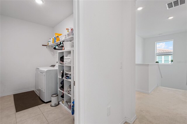 washroom featuring light tile patterned floors, visible vents, washer / dryer, laundry area, and baseboards