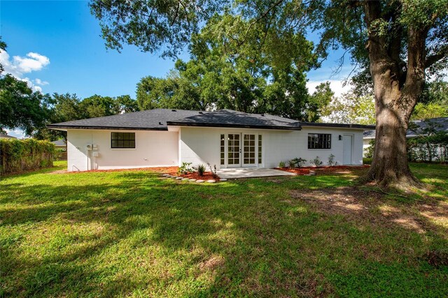 rear view of property featuring a patio area, a yard, and french doors