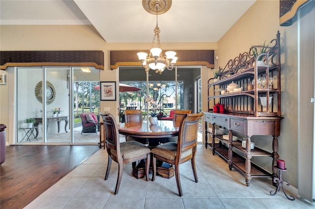 dining space featuring light hardwood / wood-style flooring, a notable chandelier, and ornamental molding