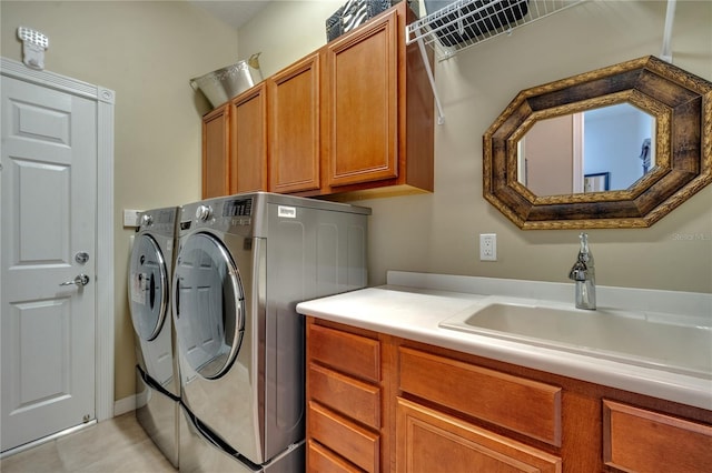 laundry area featuring sink, washer and clothes dryer, light tile patterned floors, and cabinets