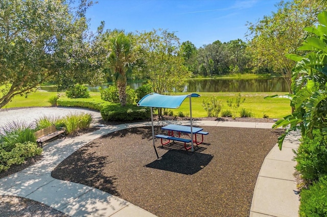 view of home's community with a yard and a water view