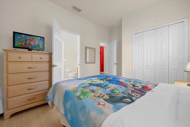 bedroom with ensuite bath, a closet, and light wood-type flooring