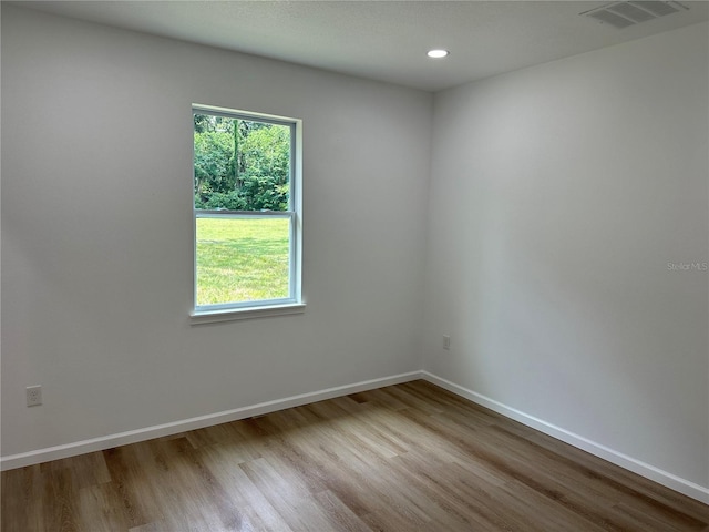 spare room with light wood finished floors, recessed lighting, visible vents, and baseboards