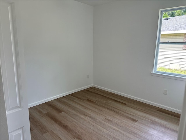 unfurnished room with light wood finished floors and baseboards