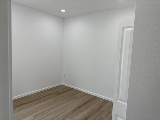 unfurnished room with baseboards, wood finished floors, and recessed lighting