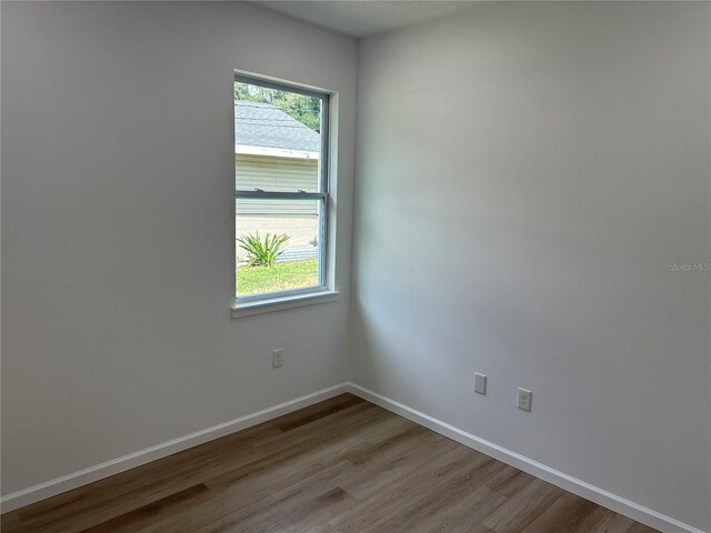 empty room with light wood-style floors, baseboards, and a wealth of natural light