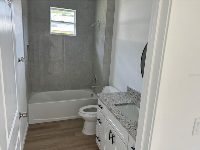 bathroom featuring toilet, shower / bath combination, wood finished floors, and vanity