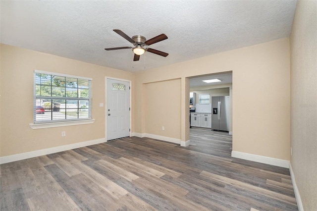 interior space featuring hardwood / wood-style flooring, ceiling fan, and a textured ceiling