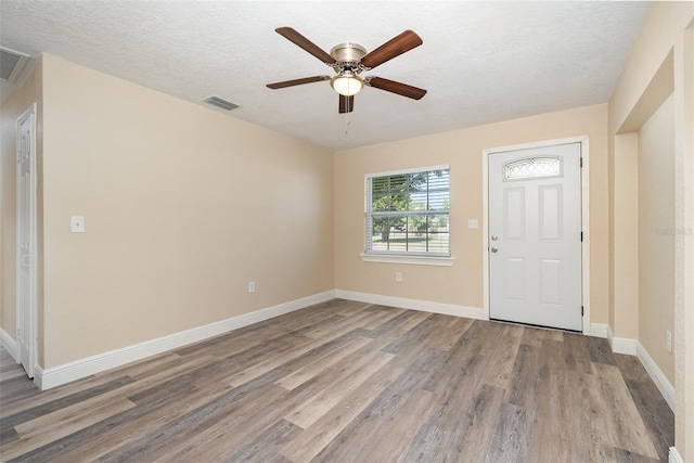 foyer entrance featuring ceiling fan, light hardwood / wood-style floors, and a textured ceiling