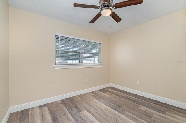 empty room featuring ceiling fan, light hardwood / wood-style flooring, and a textured ceiling