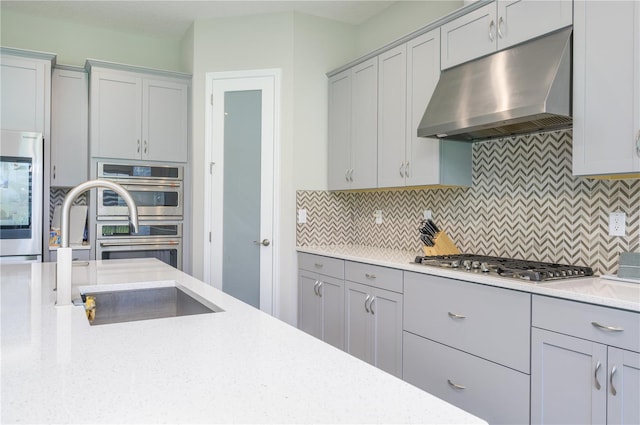 291 Mossy River Ct, Brandon, FL 33511 - kitchen with under cabinet range hood, a sink, backsplash, and appliances with stainless steel finishes