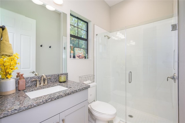 bathroom featuring vanity, an enclosed shower, and toilet