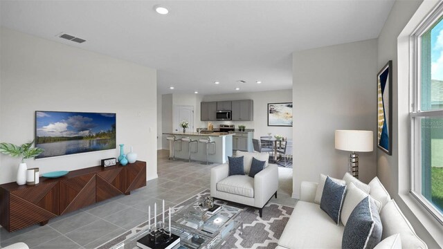 living room featuring light tile patterned floors, visible vents, and recessed lighting