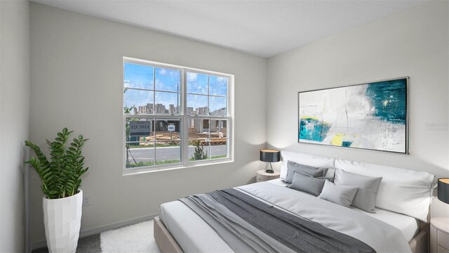 bedroom with carpet floors, a city view, and baseboards