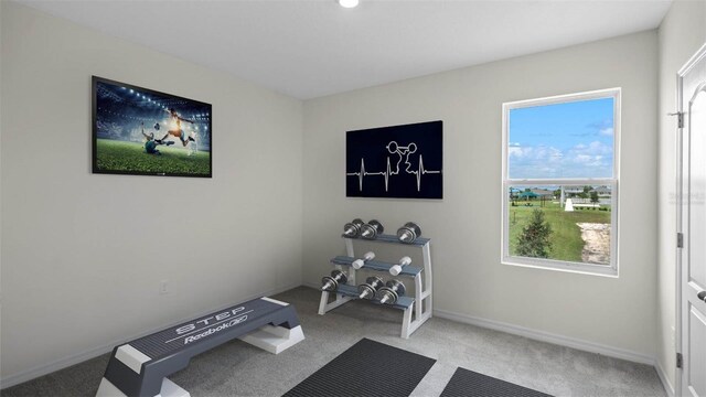 workout area with light carpet and baseboards