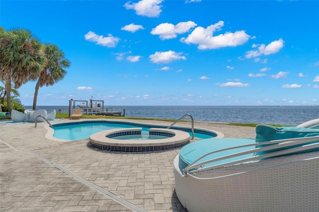 view of pool with a water view, an in ground hot tub, and a patio